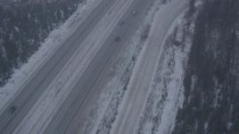 4K aerial stock footage following Glenn Highway through forest and falling snow, Anchorage, Alaska Aerial Stock Footage | AK0001_1307