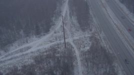 4K aerial stock footage following Glenn Highway and forest through snow, Anchorage, Alaska Aerial Stock Footage | AK0001_1308