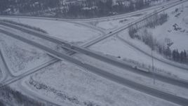 4K aerial stock footage orbiting a Glenn Highway overpass in falling snow, Eagle River, Alaska Aerial Stock Footage | AK0001_1312