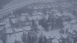 4K aerial stock footage flying over neighborhoods near Glenn Highway in falling snow, Eagle River, Alaska Aerial Stock Footage | AK0001_1315