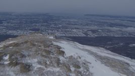 4K aerial stock footage flying over a snow covered mountain peak revealing Anchorage, Alaska Aerial Stock Footage | AK0001_1338
