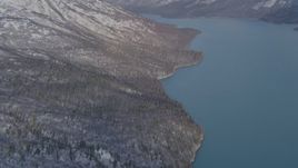 4K aerial stock footage approaching snow covered mountain slopes along shore of Eklutna Lake, Alaska Aerial Stock Footage | AK0001_1355