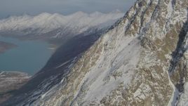 4K aerial stock footage flying toward rocky, snowy slope near Eklutna Lake, Alaska Aerial Stock Footage | AK0001_1367