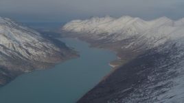 4K aerial stock footage Eklutna Lake surrounded by snow capped Chugach Mountains, Alaska Aerial Stock Footage | AK0001_1368