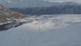 4K aerial stock footage flying along edge of snow covered Knik Glacier toward Chugach Mountains, Alaska Aerial Stock Footage | AK0001_1389
