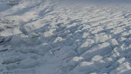 4K aerial stock footage tilting down on surface of snow covered Knik Glacier, Alaska Aerial Stock Footage | AK0001_1396