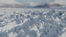 4K aerial stock footage flying low over surface of cracked, snow covered Knik Glacier, Alaska Aerial Stock Footage | AK0001_1413