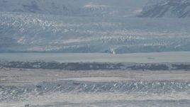 4K aerial stock footage snow covered glacier spilling into Inner Lake George, from Knik Glacier, Alaska Aerial Stock Footage | AK0001_1429