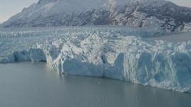 4K aerial stock footage flying toward edge of glacier on Inner Lake George, snow covered peak, Alaska Aerial Stock Footage | AK0001_1445