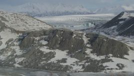4K aerial stock footage flying over snowy ridge toward the glacier on Inner Lake George, Alaska Aerial Stock Footage | AK0001_1472
