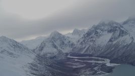 4K aerial stock footage panning across snow covered Chugach Mountains revealing Eklutna Lake, Alaska Aerial Stock Footage | AK0001_1494