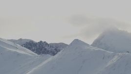 4K aerial stock footage a snowy ridge, low clouds, rocky mountain ridges, Chugach Mountains, Alaska Aerial Stock Footage | AK0001_1501