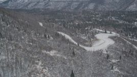 4K aerial stock footage road through snowy, wooded foothills, Chugach Mountains, Alaska Aerial Stock Footage | AK0001_1512