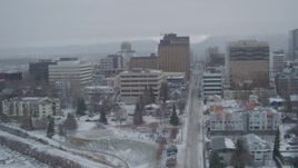 4K aerial stock footage flying over Cook Inlet into snowy Downtown Anchorage, West 5th Avenue, Alaska Aerial Stock Footage | AK0001_1524