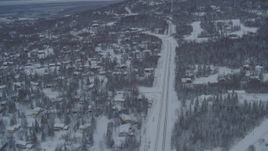4K aerial stock footage following Eagle River Loop Road through snow covered neighborhoods, Alaska Aerial Stock Footage | AK0001_1536