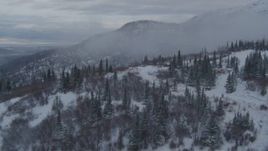 4K aerial stock footage flying low over homes on snowy foothills, Eagle River, Alaska Aerial Stock Footage | AK0001_1537