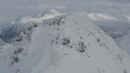 4K aerial stock footage flying over snowy summit revealing snow capped Chugach Mountains, Alaska Aerial Stock Footage | AK0001_1546