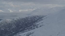 4K aerial stock footage the snowy Chugach Mountains, cloud covered Eklutna Lake Valley, Alaska Aerial Stock Footage | AK0001_1547