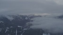 4K aerial stock footage flying between clouds near Chugach Mountains, Alaska in snow Aerial Stock Footage | AK0001_1552