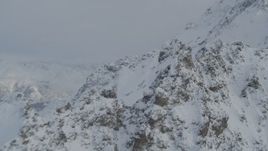 4K aerial stock footage flying by snow covered rocky mountain ridges, Chugach Mountains, Alaska Aerial Stock Footage | AK0001_1565