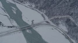 4K aerial stock footage a reverse view of the Old Glenn Highway bridges spanning Knik River, Alaska in snow Aerial Stock Footage | AK0001_1572