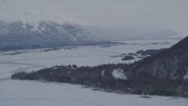 4K aerial stock footage descending toward a house in snow covered Knik River Valley, Alaska Aerial Stock Footage | AK0001_1577