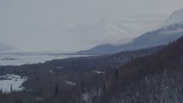 4K aerial stock footage descending along snowy, wooded slope on rim of Knik River Valley, Alaska Aerial Stock Footage | AK0001_1578
