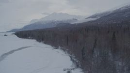 4K aerial stock footage flying along snow covered, wooded rim of Knik River Valley, Alaska Aerial Stock Footage | AK0001_1582