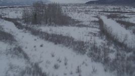 4K aerial stock footage flying low over snow covered ground of the Knik River Valley, Alaska Aerial Stock Footage | AK0001_1595