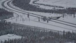 4K aerial stock footage flying by Eagle River Loop Road overpass over Glenn Highway, Alaska in snow Aerial Stock Footage | AK0001_1637