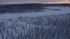 4K aerial stock footage flying low over frozen, snowy ground at twilight on Point MacKenzie, Alaska Aerial Stock Footage | AK0001_1671