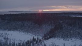 4K aerial stock footage flying over snow covered forest on Point MacKenzie at sunset, Alaska Aerial Stock Footage | AK0001_1673