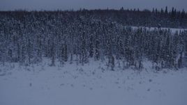 4K aerial stock footage flying over frozen, snowy ground and woods at twilight in Point MacKenzie, Alaska, reveal Downtown Anchorage Aerial Stock Footage | AK0001_1681