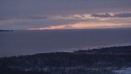 4K aerial stock footage twilight lit clouds over Cook Inlet seen from snow covered Point MacKenzie, Alaska Aerial Stock Footage | AK0001_1689