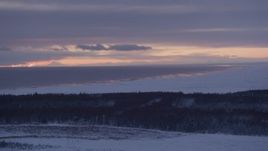 4K aerial stock footage twilight lit clouds over Cook Inlet seen from snow covered Point MacKenzie, Alaska Aerial Stock Footage | AK0001_1690