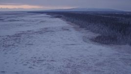 4K aerial stock footage flying over frozen, snow covered ground at twilight, Point MacKenzie, Alaska Aerial Stock Footage | AK0001_1693
