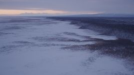 4K aerial stock footage flying over frozen, snow covered ground at twilight, Point MacKenzie, Alaska Aerial Stock Footage | AK0001_1695