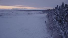 4K aerial stock footage flying low over frozen, snow covered ground at twilight, Point MacKenzie, Alaska Aerial Stock Footage | AK0001_1698