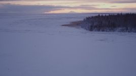 4K aerial stock footage descending low over frozen, snowy ground at twilight, Point MacKenzie, Alaska Aerial Stock Footage | AK0001_1700