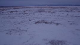 4K aerial stock footage flying over frozen, snow covered ground at twilight, Point MacKenzie, Alaska Aerial Stock Footage | AK0001_1711