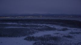 4K aerial stock footage Downtown Anchorage skyline, snowy ground, Point MacKenzie, Alaska, night Aerial Stock Footage | AK0001_1717