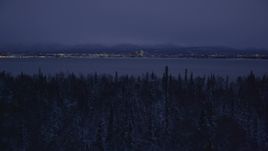 4K aerial stock footage ascend from snowy trees, reveal Downtown Anchorage, Alaska, night Aerial Stock Footage | AK0001_1718