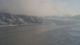 4K aerial stock footage fly through low clouds over snowy Turnagain Arm of the Cook Inlet, Alaska Aerial Stock Footage | AK0001_1740