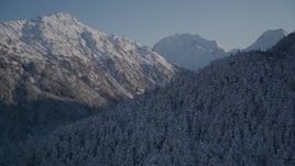 4K aerial  video rounding snowy, wooded peak, reveal double peak, Chugach Mountains, Alaska Aerial Stock Footage | AK0001_1761