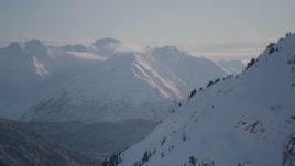 4K aerial stock footage rounding a snowy slope revealing Carmen Lake, Chugach Mountains, Alaska Aerial Stock Footage | AK0001_1765