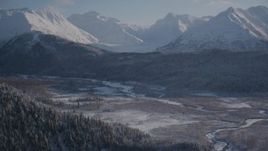 4K aerial stock footage wooded slopes and river valley, tilt up to snow capped Chugach Mountains, Alaska Aerial Stock Footage | AK0001_1766