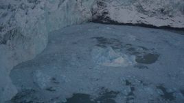 4K aerial stock footage pan from edge of snow covered glacier, to Harriman Fjord, revealing chunk of glacial ice, Alaska Aerial Stock Footage | AK0001_1817