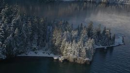 4K aerial stock footage descending toward water near snowy, wooded peninsula, Port Wells, Alaska Aerial Stock Footage | AK0001_1851