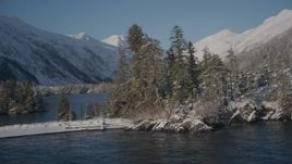 4K aerial stock footage orbiting by a snowy, wooded mountain and small islands in Port Wells, Alaska Aerial Stock Footage | AK0001_1860