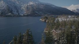 4K aerial stock footage flying along snowy shore, rounding it to reveal Bettles Bay, Port Wells, Alaska Aerial Stock Footage | AK0001_1870